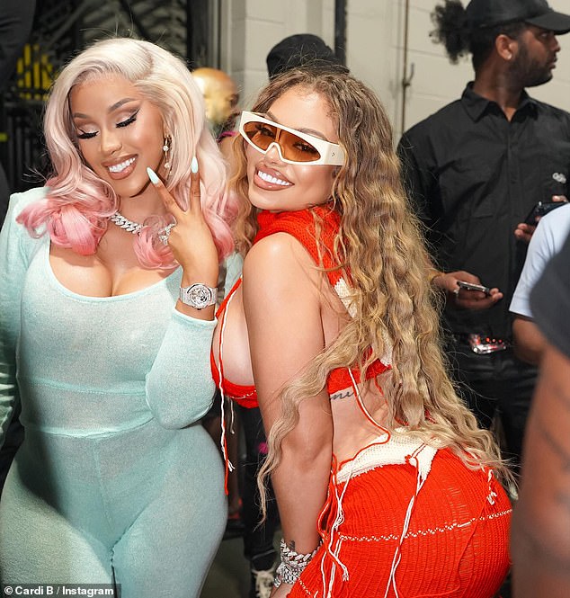 Making memories: In another pH๏τo, Cardi B flashed a cheerful smile and held up a peace sign with her hand as she posed next to fellow rapper, Latto
