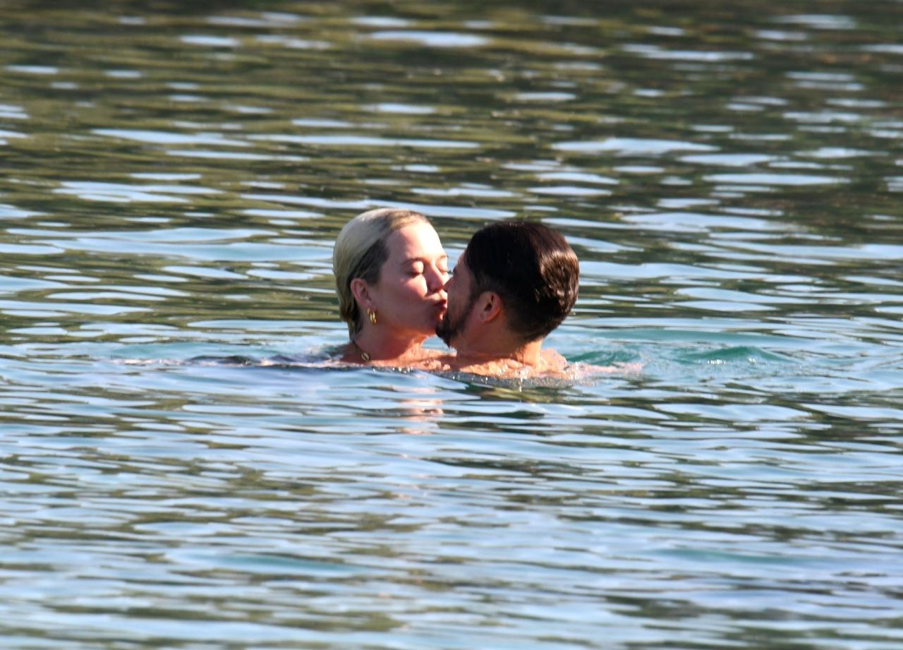 The engaged couple passionately kissed in the water