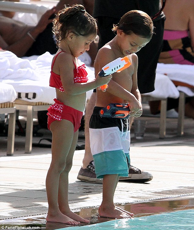 Gun fight! Emme and Max play with water guns by the side of the pool
