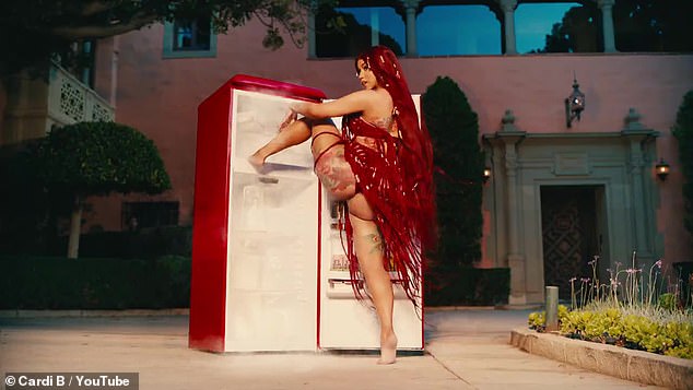 Fridge: The rapper is then seen twerking while standing in front of an open refridgerator before cutting back to Cardi and her lounge chair twerkers