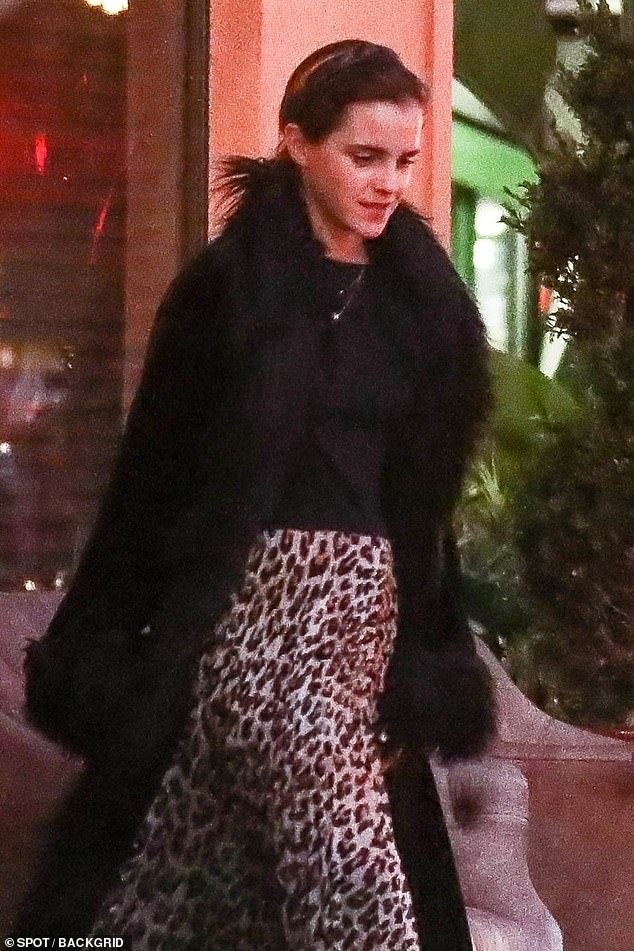 Off she goes: The screen star looked effortlessly chic as she donned a fierce leopard print floor-length skirt, teamed with a black coat with feathered cuffs and a matching collar
