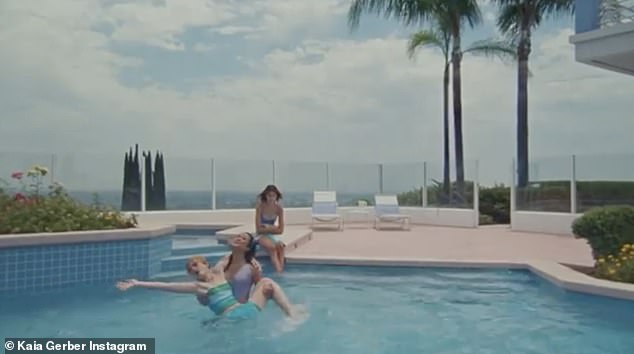 Doesn't fit in: The model watches her friends splash around in the pool without her