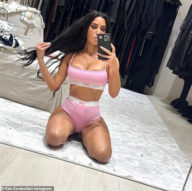 Pretty in pink: Kim Kardashian looked fitter then ever as she flaunted her 24in waistline in a figure hugging set of Skims underwear and a matching bra on Sunday