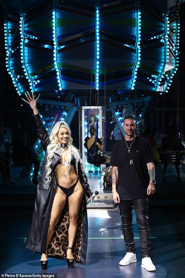 Hostess: Saweetie was in Italy, wearing little more than a bikini, to appear at designer Philipp Plein's (R) SS/24 presentation during Milan Fashion Week on Saturday