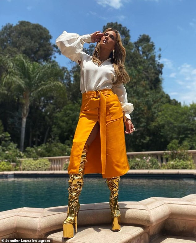 Takes balance! The megastar dressed up a rather tailored look with edgy platform gold boots that went over her knees and she paired the metallic footwear with gold earrings from St. John