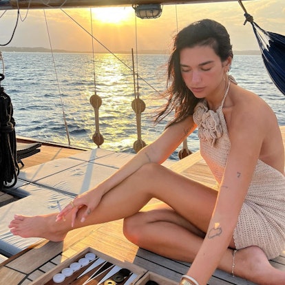 Dua Lipa wears a backless halter dress in a pH๏τo posted to her Instagram.