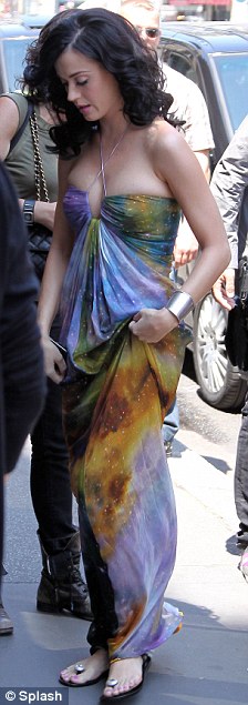 Different continents: Katy Perry in a maxi dress in Paris today (left) as her fiance Russell Brand chows down in New York