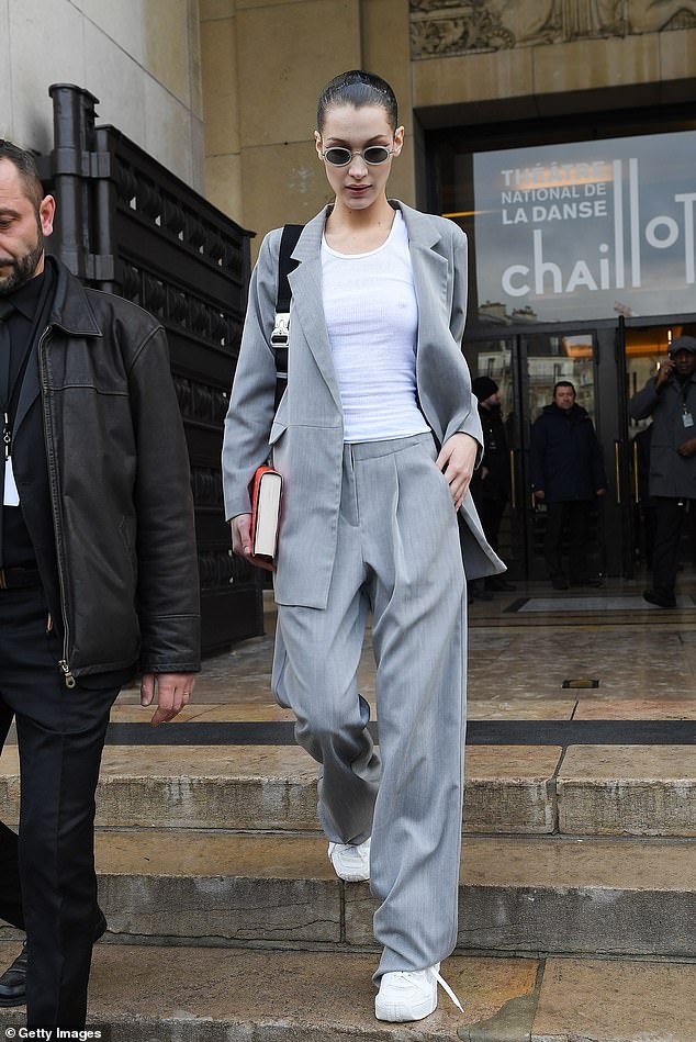 Another day, another catwalk: Bella Hadid went braless in a flimsy vest top after storming the runway at Haider Ackermann Paris Fashion Week show on Friday