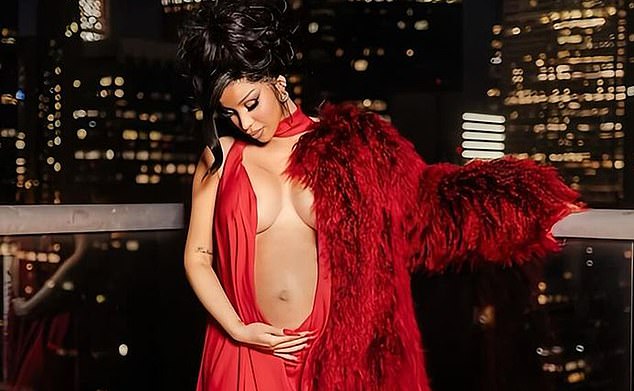 The rapper displayed her baby bump in a deeply plunging red gown as she posed on a balcony at night